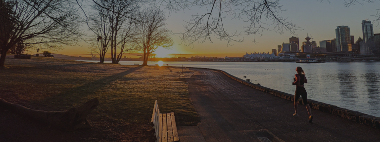 Woman running along the Vancouver waterfront trail.