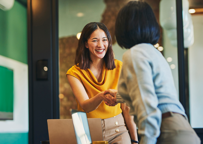 A business owner shaking hands with a customer.