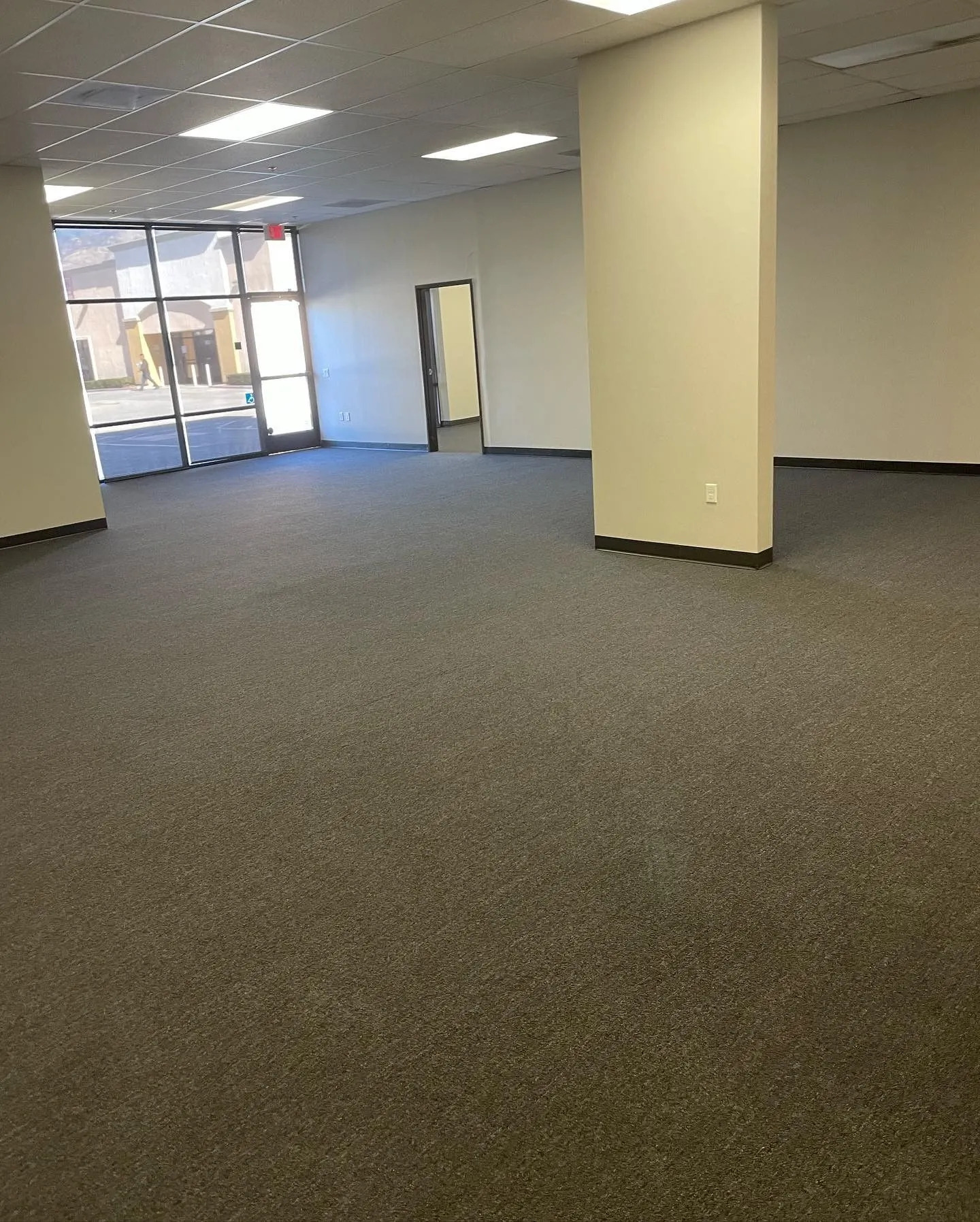 Spacious commercial interior build-out featuring new carpet flooring, painted walls, suspended ceili 