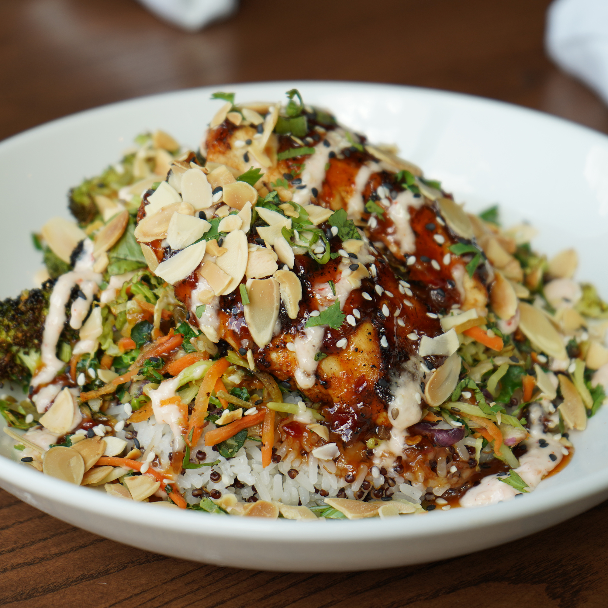 Bronzed chicken, general tso glaze, charred broccoli, rice & quinoa blend, julienned vegetables, toasted almonds, scalions, cilantro, sesame seeds, ginger aioli.