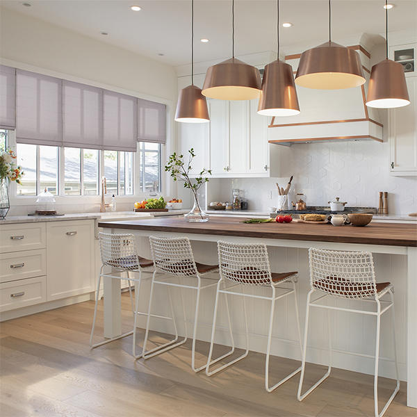 The right window treatment can do wonders for a space! These Roman shades do a fantastic job matching the bright feel of this kitchen while offering plenty of window coverage.