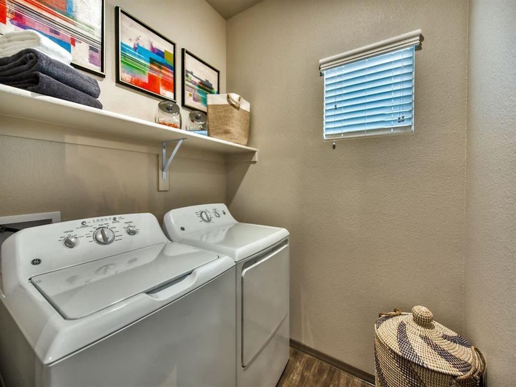 Washer and Dryer with a small shelf above them and a small window with blinds