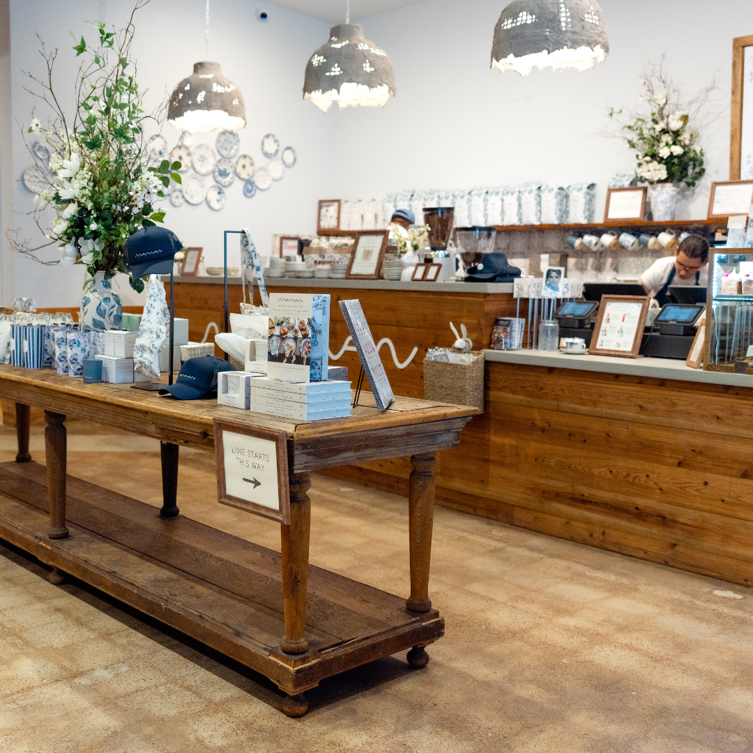 A space that features a rustic wooden table at the foreground, which displays various merchandise it 