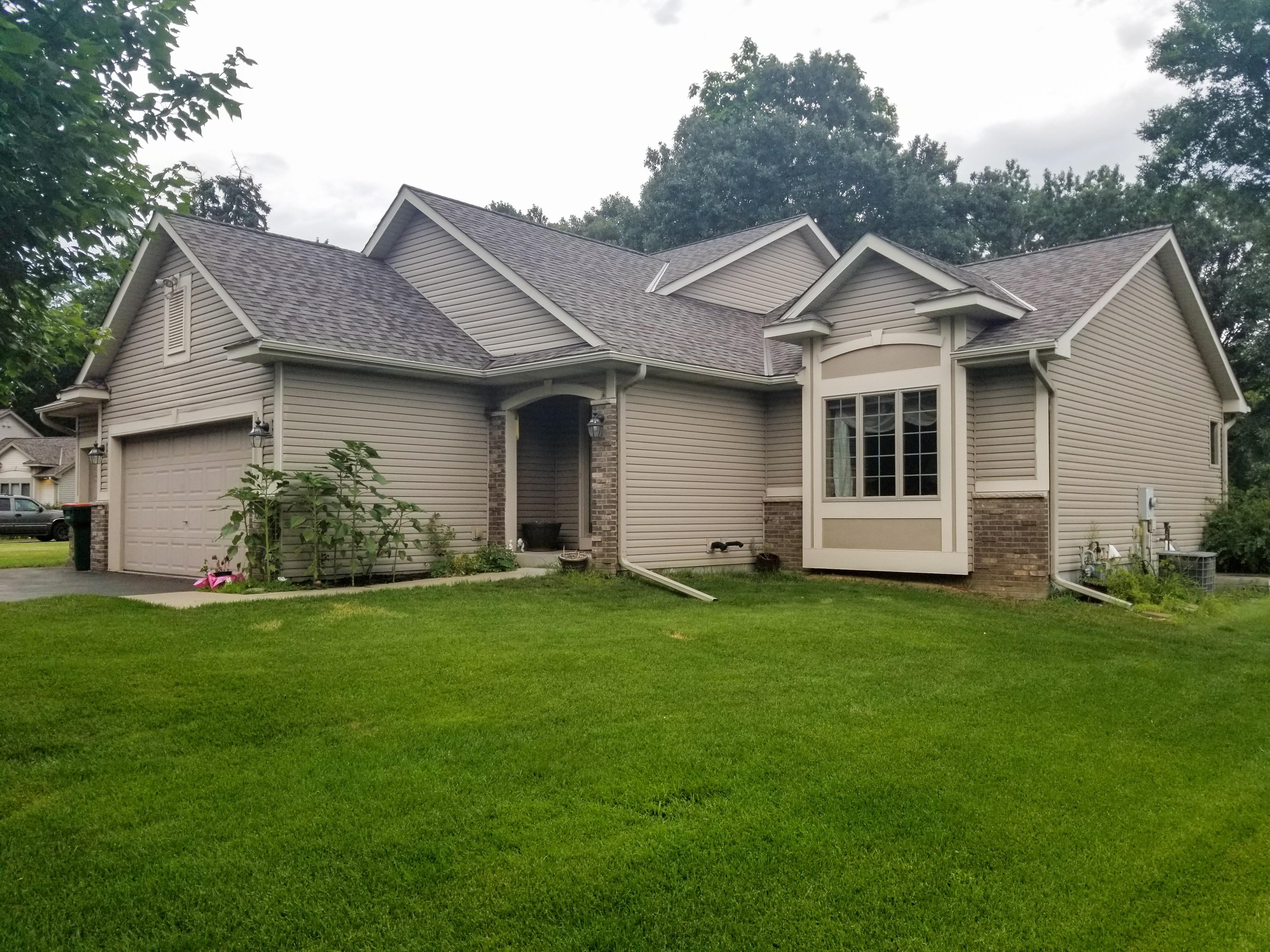 Custom color seamless gutters and downspouts installed to match a tan single-story home by Ultimate Gutter Solutions.