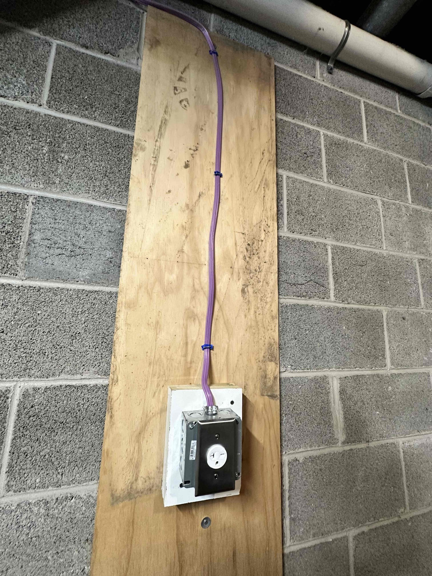 Thomas Edison Electric installed a dedicated 240-volt outlet on a plywood backer in a Reading, PA basement. The surface-mounted box and secured cable run provide a clean, code-compliant connection for heavy-duty equipment like a dryer or workshop tools.