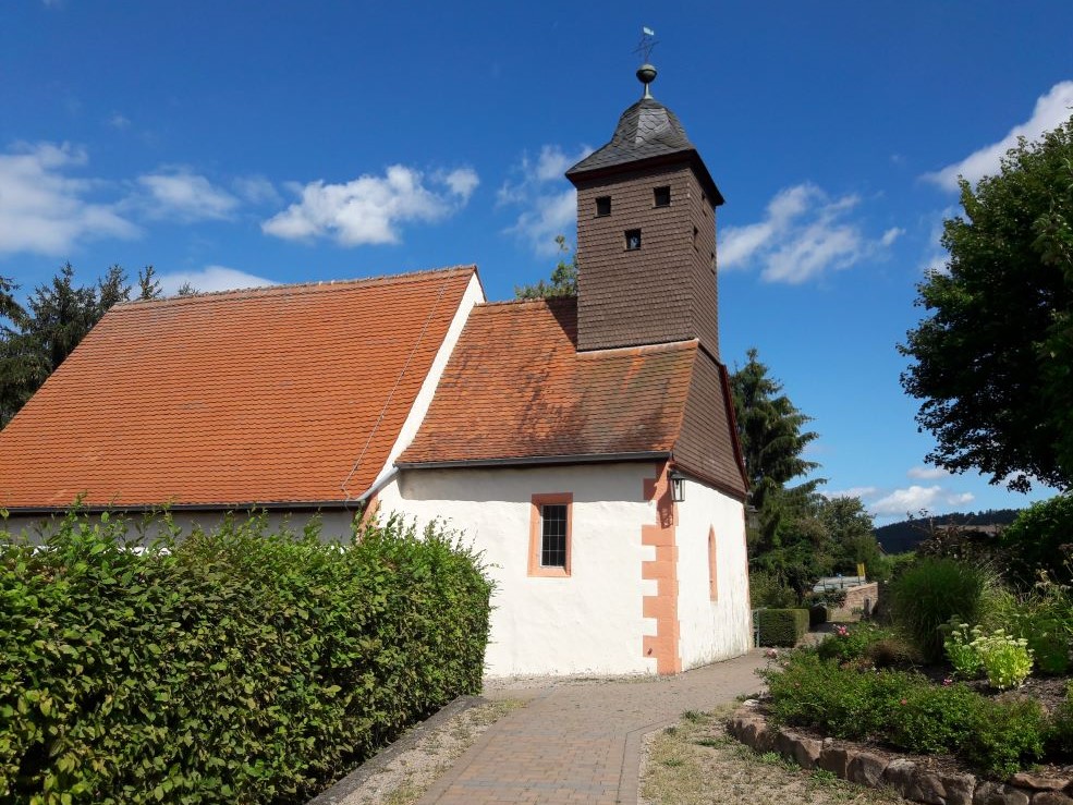 Die Kirche in Rai-Breitenbach ist eine der ältesten Kirchen des Odenwalds, deutlich erkennbar an der romanischen Grundform und dem romanische Bogen vom Kirchenschiff zum Chorraum hin. Auch ein romanisches Taufbecken ist noch erhalten.