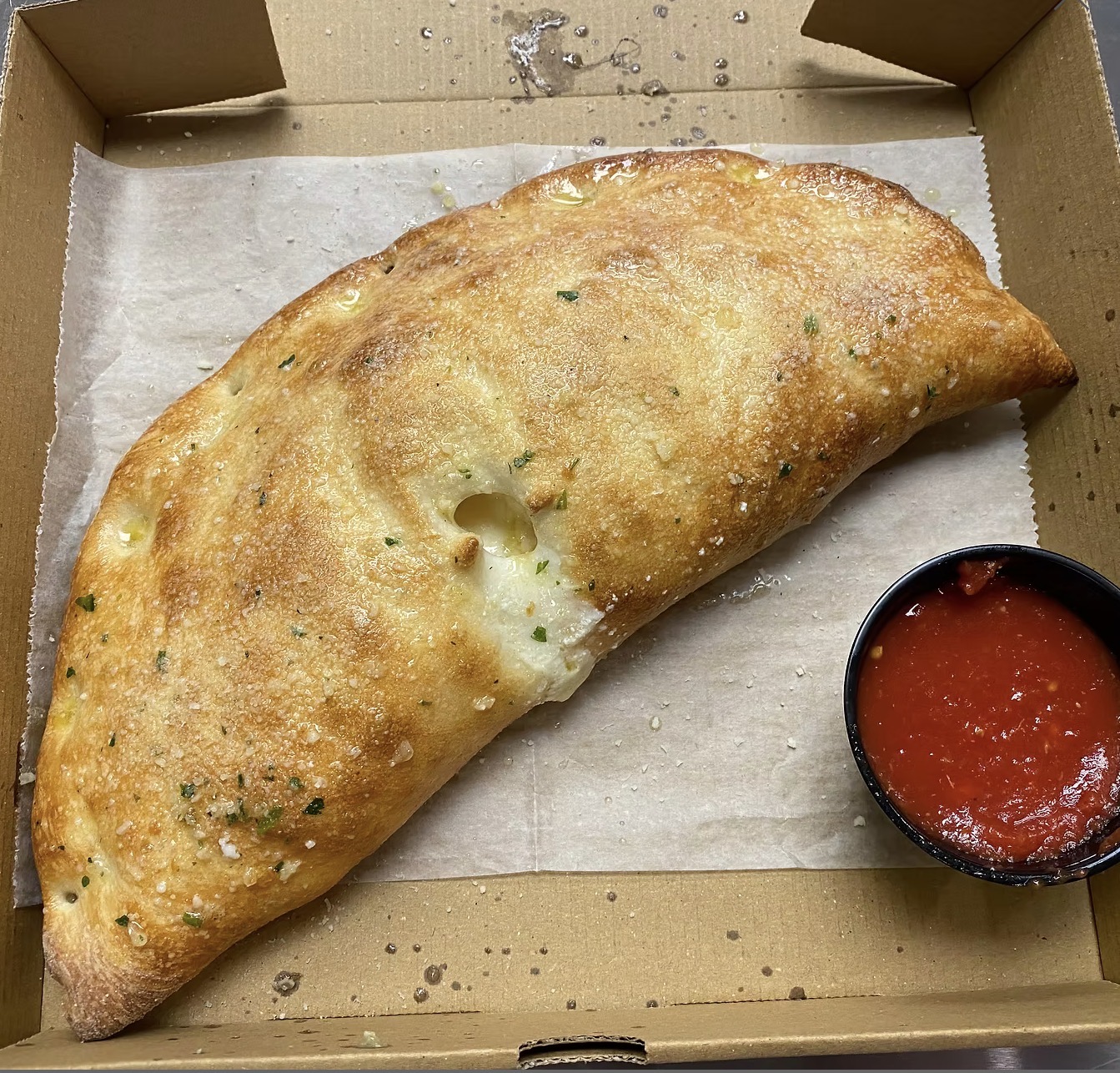 Mozzarella and ricotta cheese calzone, brushed with a light butter and garlic glaze. Topped with fresh grated parmesan cheese. Served with a side of marinara.