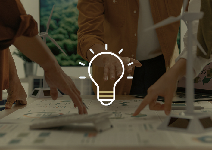 Several hands pointing at reports spread across a desk.