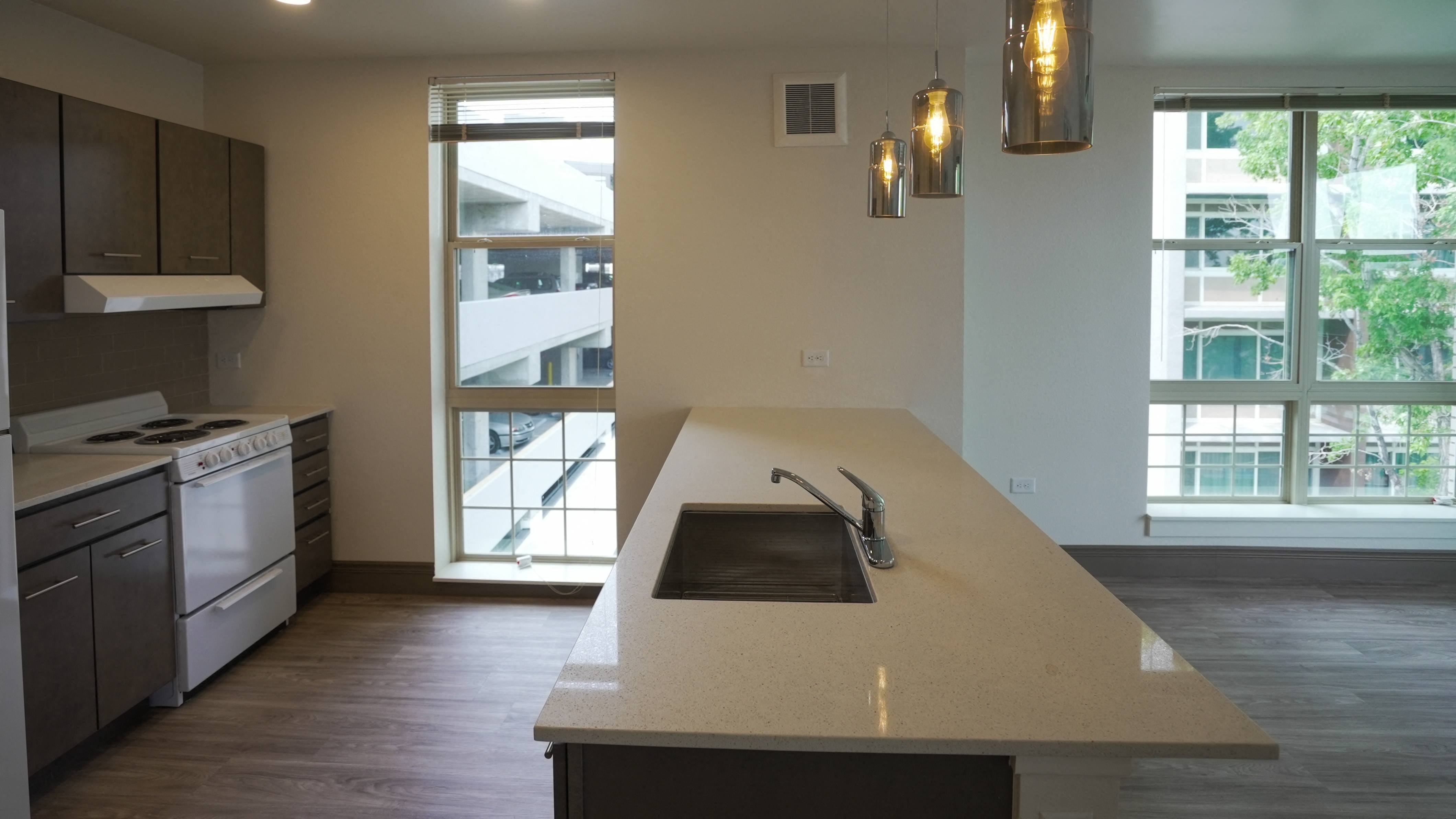 A modern kitchen with a large island and a view of the outside