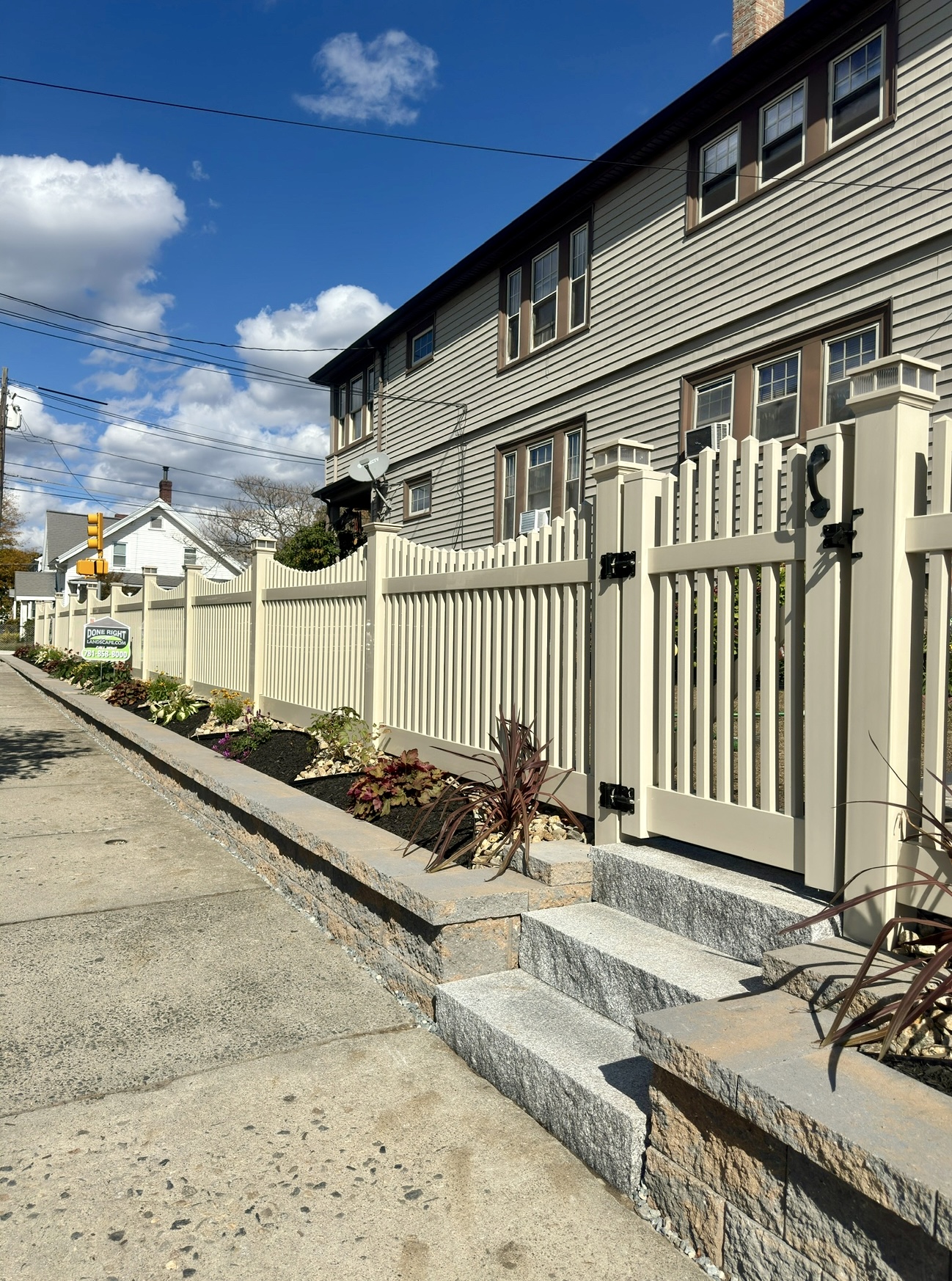 Beige Scalloped Vinyl Fence with GateSolar caps Granite Steps Nicolock Retaining wall and landscaping design by Done Right Landscape & Construction