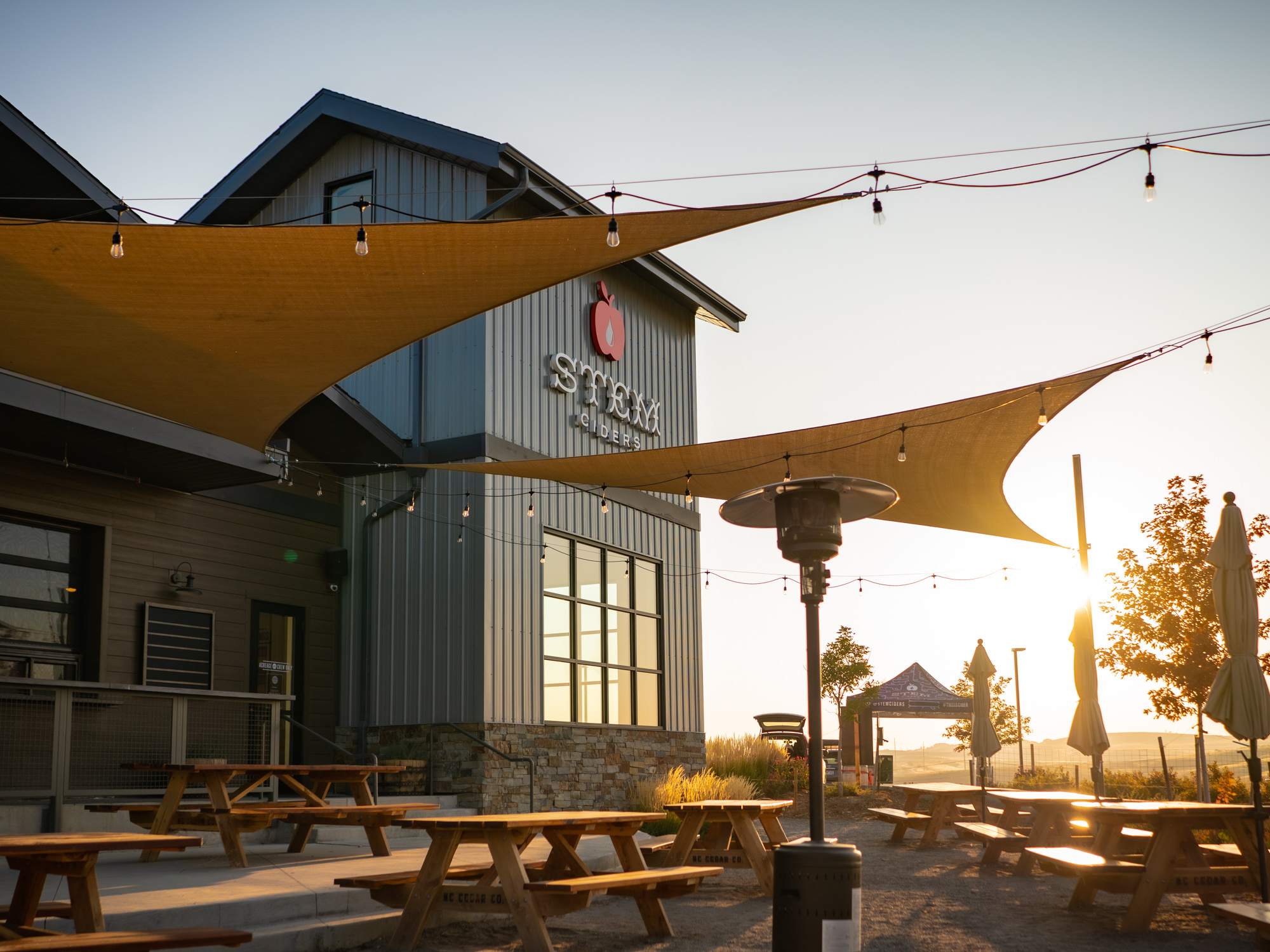 Golden hour illuminates the Acreage patio, offering guests a scenic destination for cider, dining, and Front Range views.