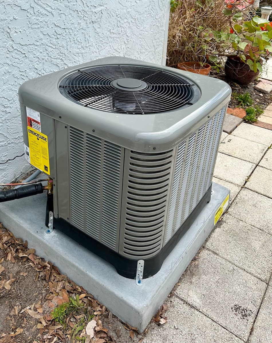 Outdoor residential air conditioning condenser installed on a concrete pad for dependable home cooling performance.