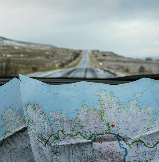 A folding map opened up on a car dashboard.
