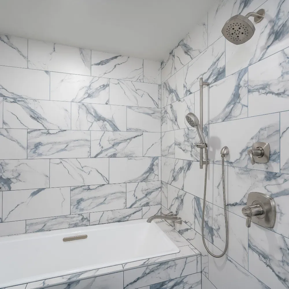 High-end custom shower renovation near Badin Lake, North Carolina with marble tile walls, frameless glass enclosure, and premium fixtures. This bathroom remodel demonstrates precision tile work and expert residential remodeling craftsmanship.