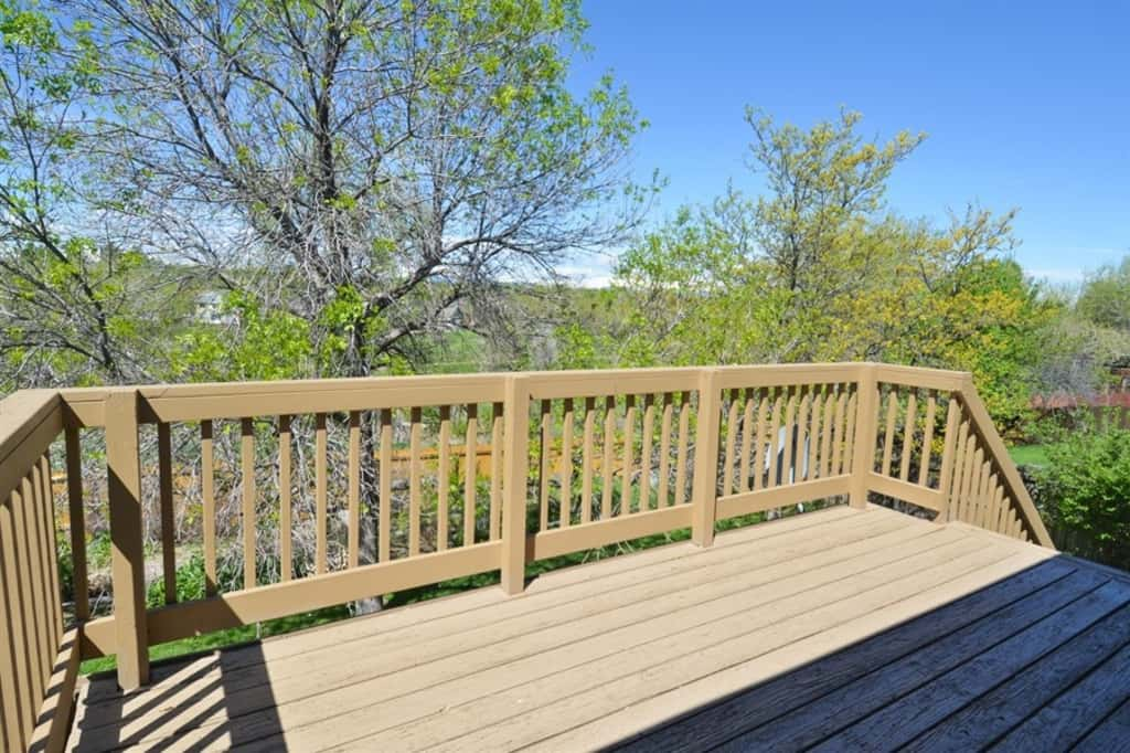 Elevated deck with stairs leading down to the backyard at Invitation Homes Denver.