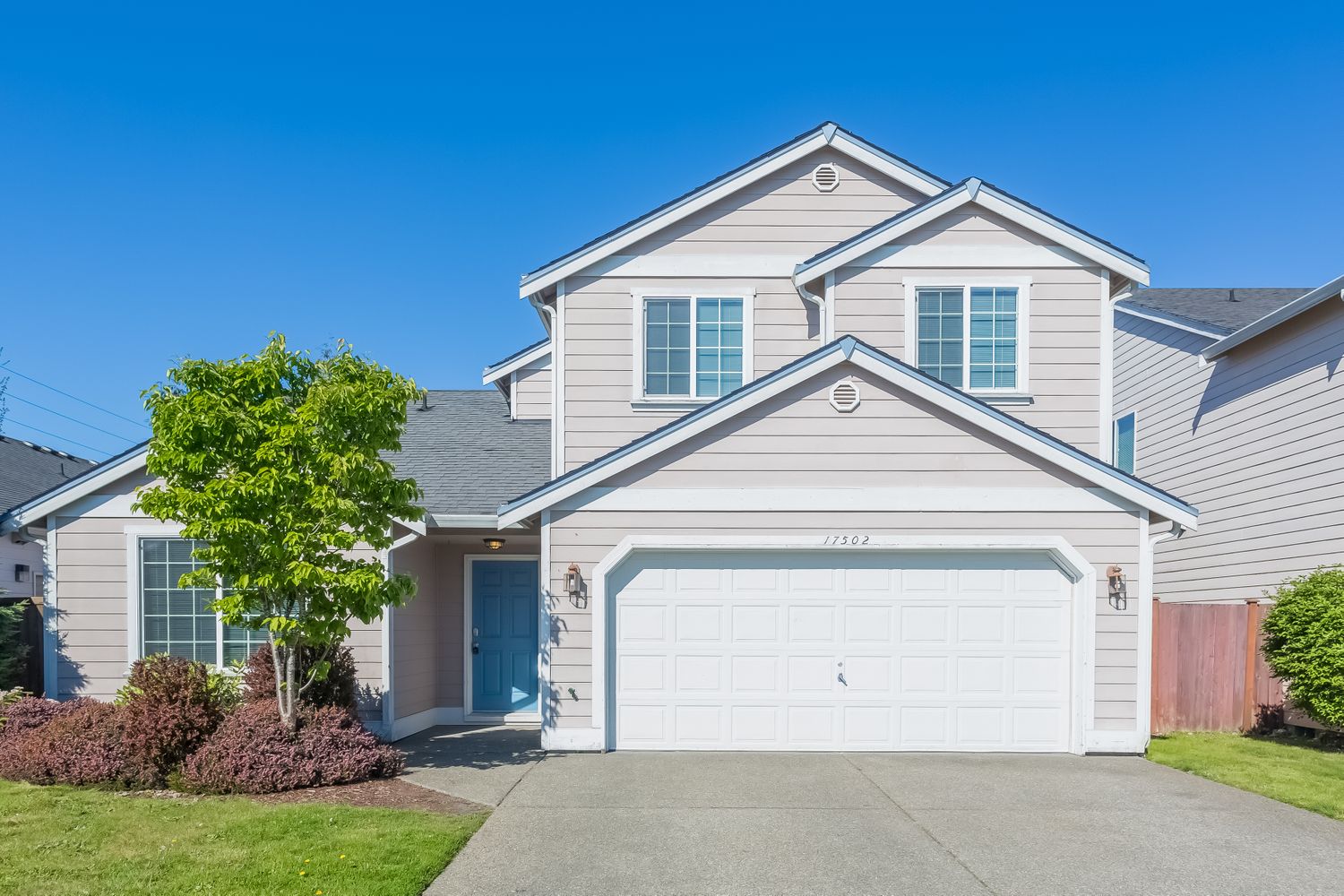 Front of home shot with a two-car garage, covered entry and stunning curb appeal at Invitation Homes Seattle.