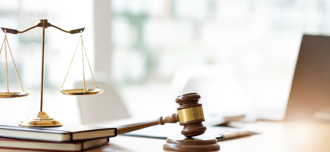 A gavel and the scales of justice on a desk.