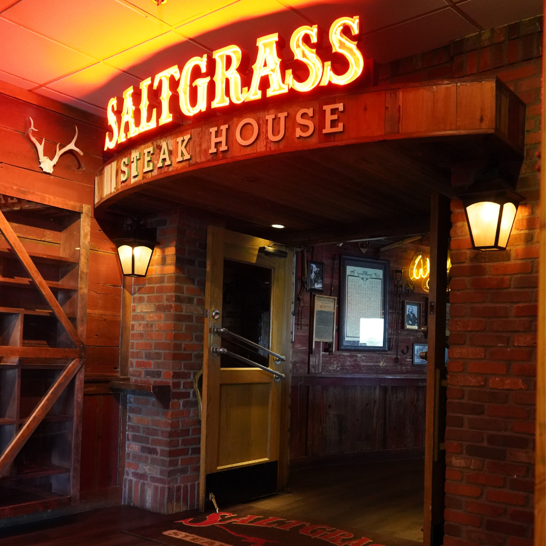 Rustic steakhouse entrance with glowing Saltgrass Steak House sign