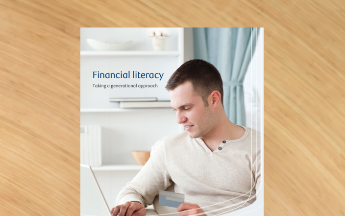 Cover of the financial literacy guide with a young man on his laptop.