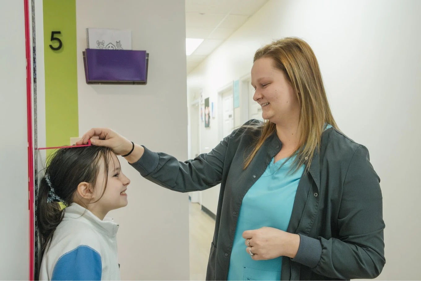 A+ Pediatrics team member measuring a child&rsquo;s height during a pediatric visit in Irvine, Kentucky.