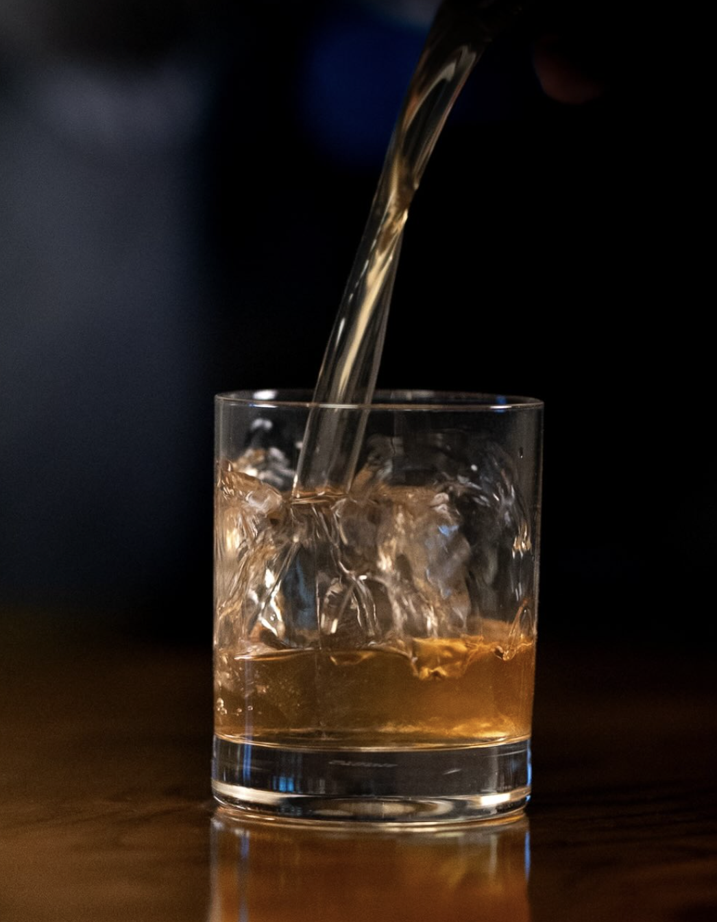 Fine whiskey being poured in a glass.