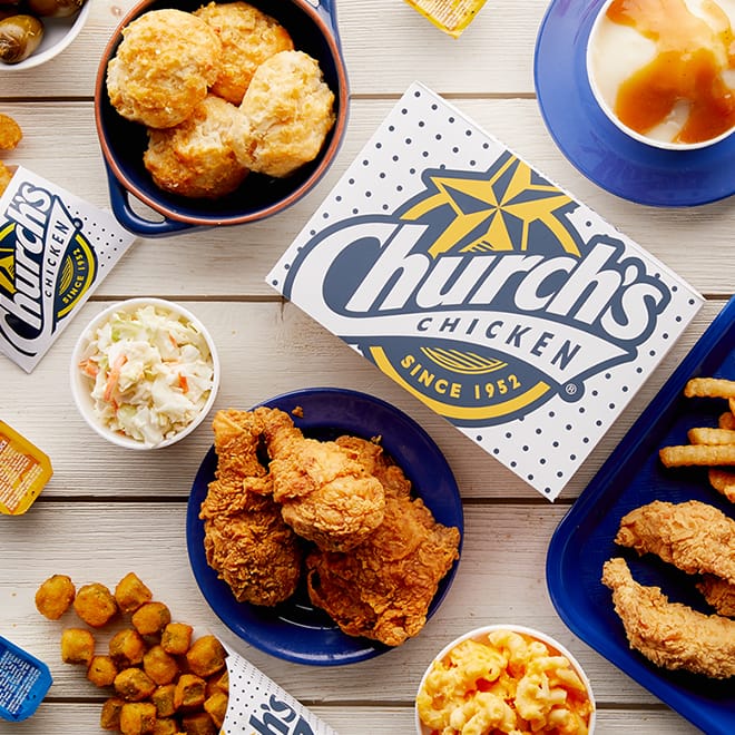 Church's Chicken-Box mit gebackenem Hähnchen auf blauem Teller, Texas Tenders, Kartoffelpüree, Pommes frites & Honey-Butter Biscuits