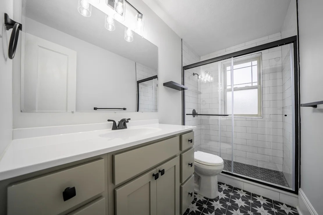 A white sink with a black and white tiled floor.