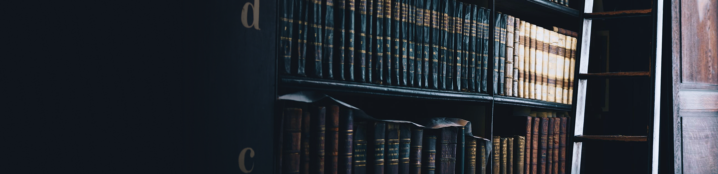 Des rangées de livres reliés en cuir sur les étagères d'une bibliothèque.