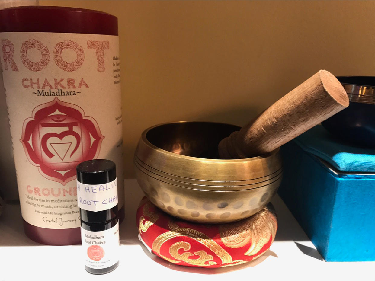 Chakra singing bowl, candle and oil that can be used to help balance chakras.