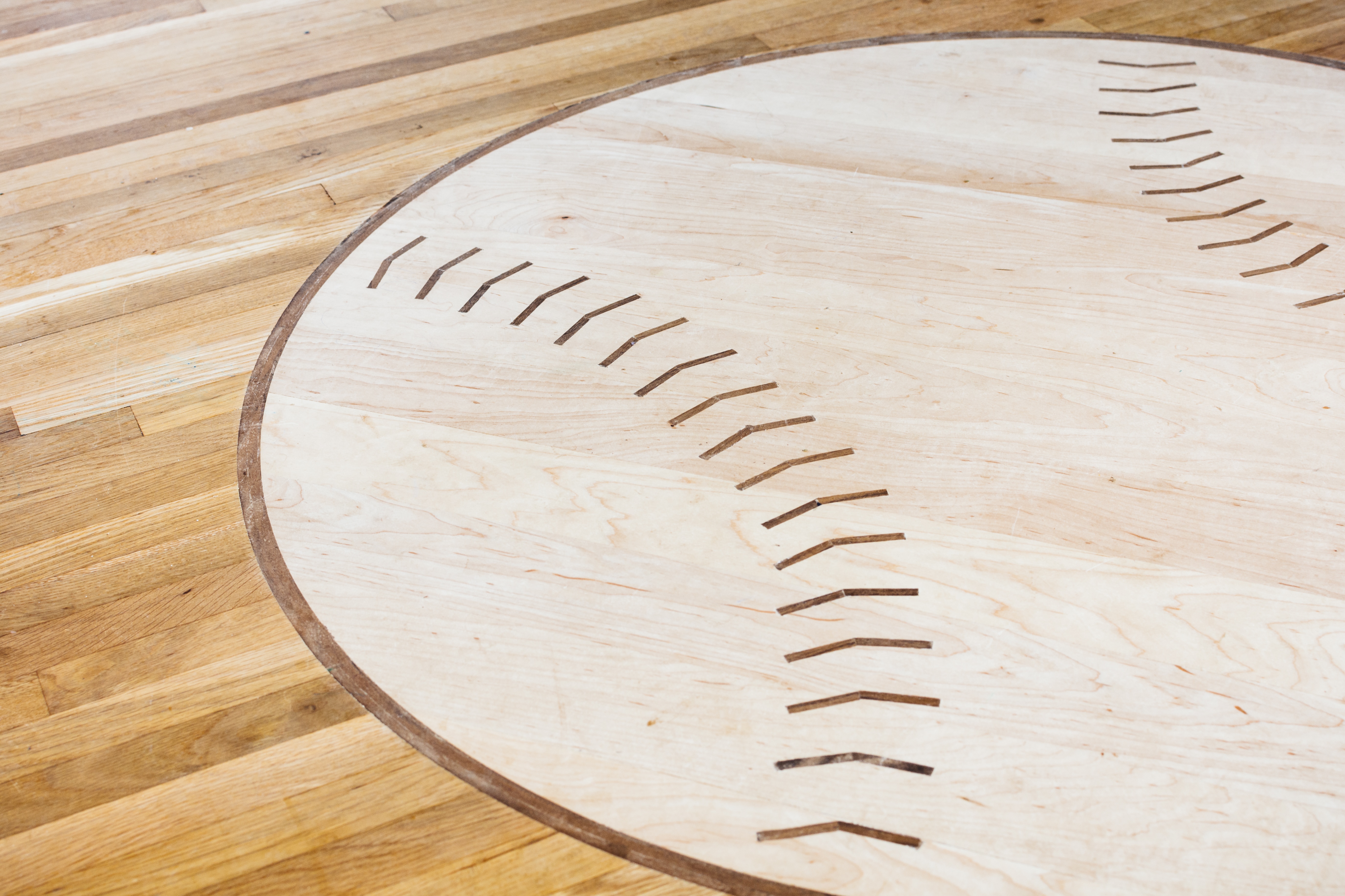 Say "custom hardwood floor design" and most people probably think of a herringbone floor or a more formal pattern we're accustomed to seeing in large, historic buildings . They probably don't think of baseball medallion. But we do!