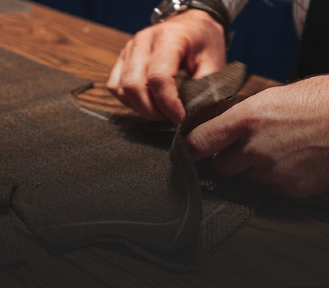 Close-up of a tailor's hands as he works on a suit.