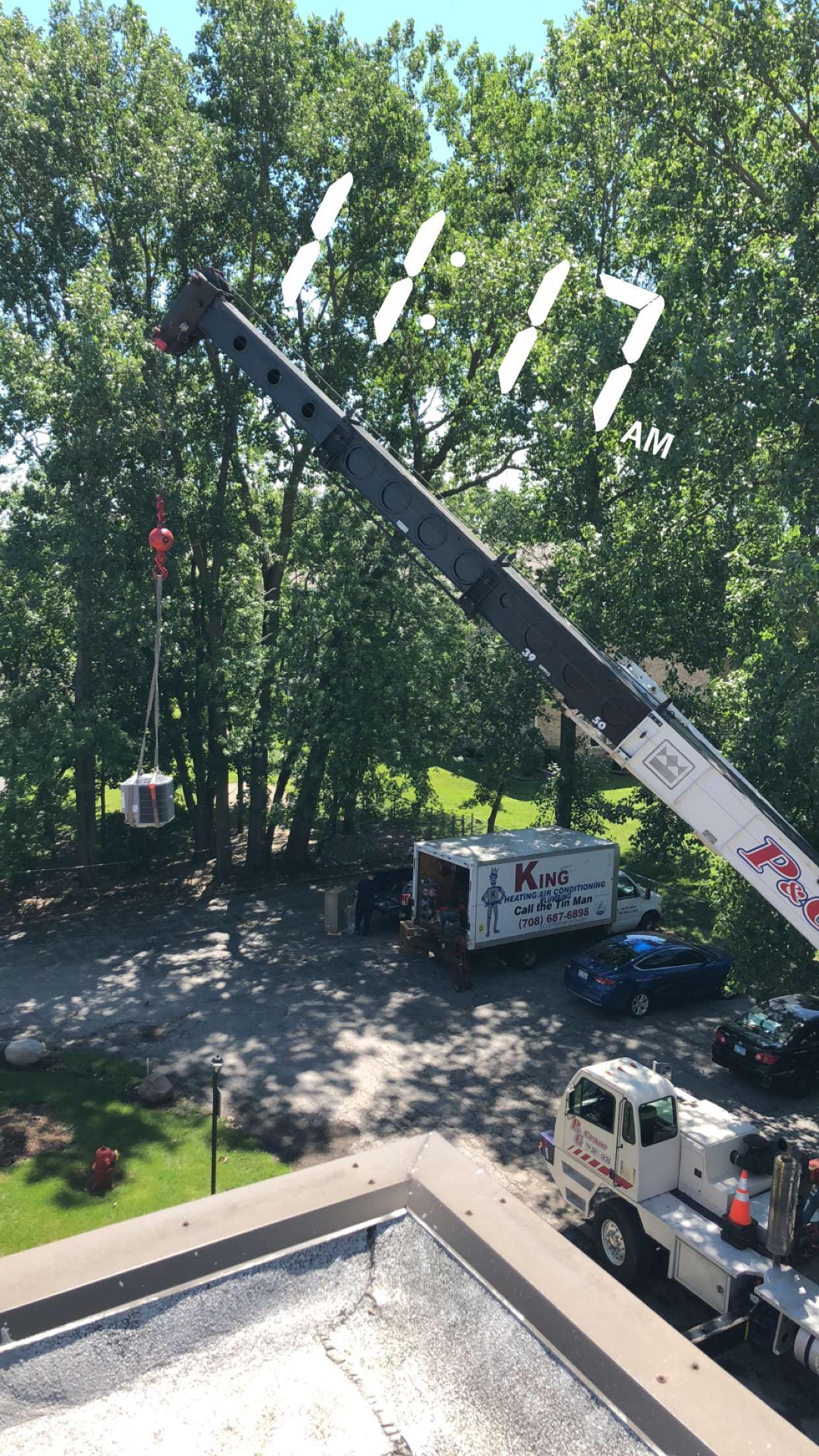 Crane lifting a new air conditioning system into place.