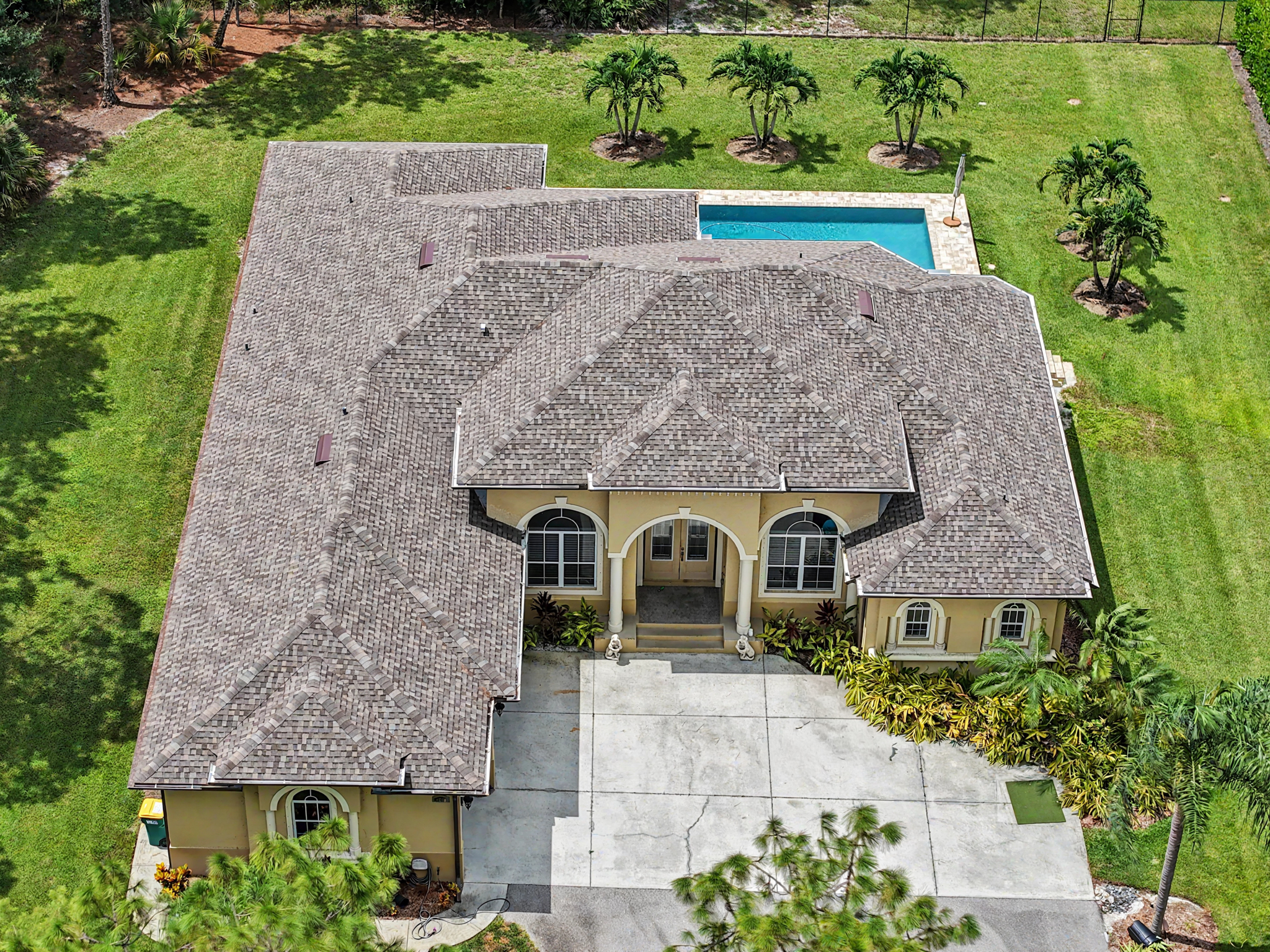 Overhead aerial view of a large residence with an architectural shingle roof, multiple roof sections 