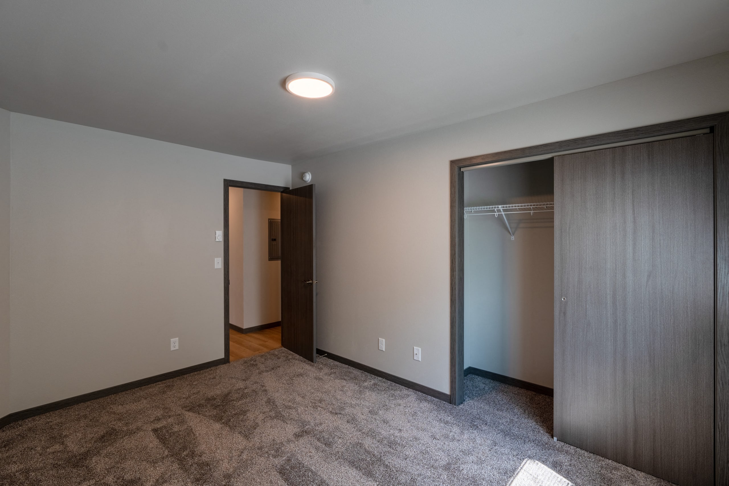 An empty room with a closet and a door to a wardrobe