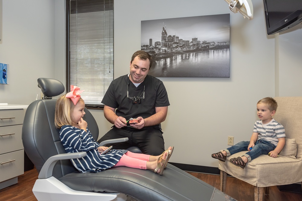 Family-friendly dental visit at Hill Family Dental Columbia with a dentist caring for young children in a comfortable setting.