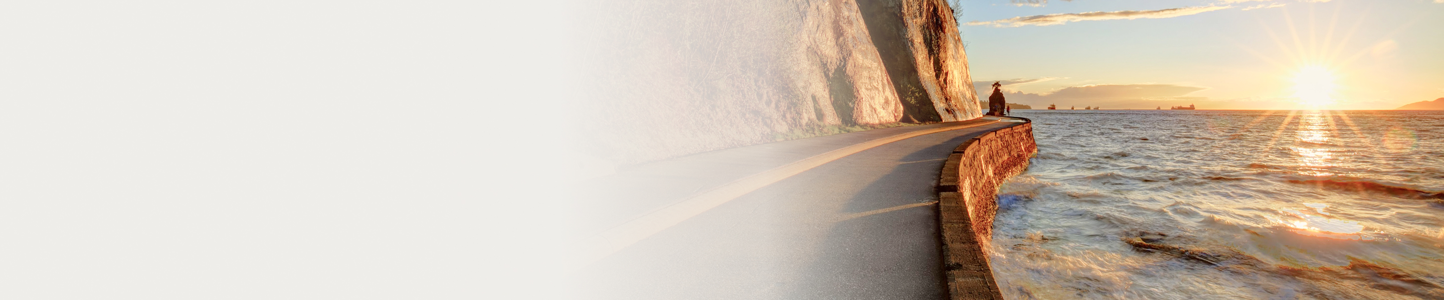 The Vancouver seawall at sunset, with the sun glistening off the water.