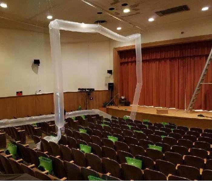 Here is an auditorium to a music studio and art school. You can see in the photo that all of our fans across the seating are faced upward towards the ceiling. This is to circulate the air throughout the whole room and make sure to dry out the ceiling which was where the water damage had begun.