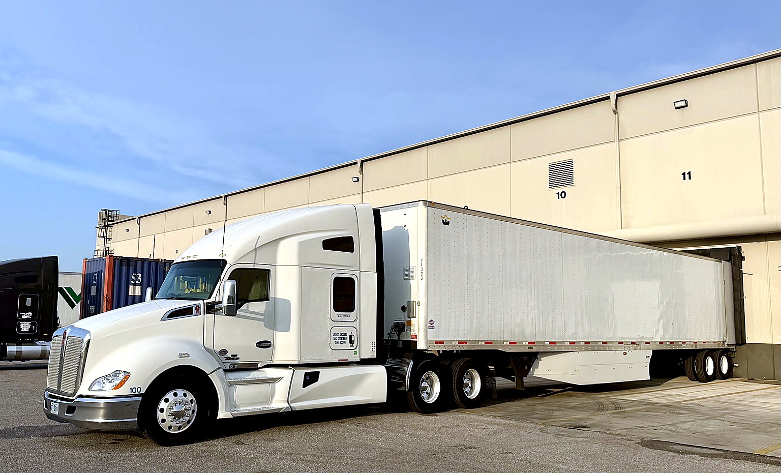 AeroLuxe Ground Inc. commercial tractor-trailer positioned at a warehouse loading dock for freight p 
