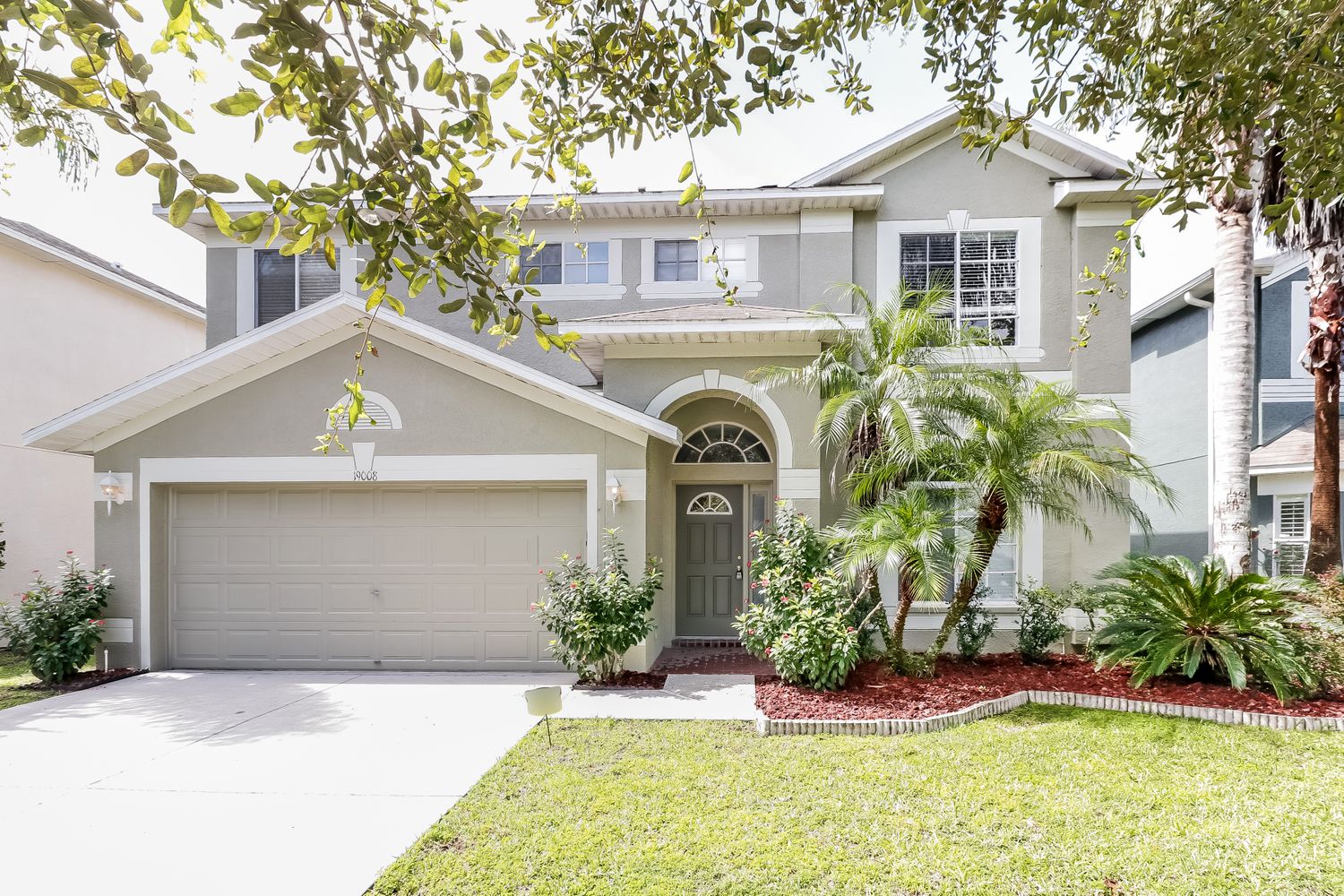 Front of home with driveway and two-care garage at Invitation Homes Tampa.