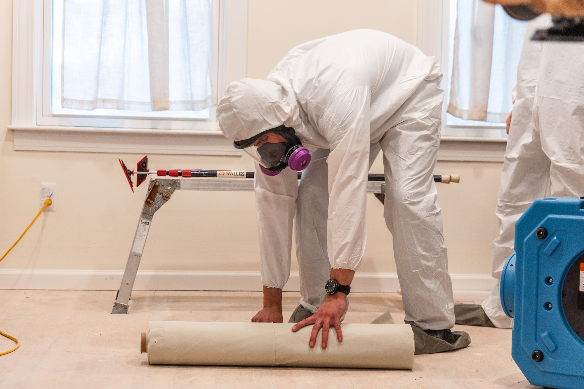 Rolling out protective material during a CT Mold Remediation Specialists remediation project. 