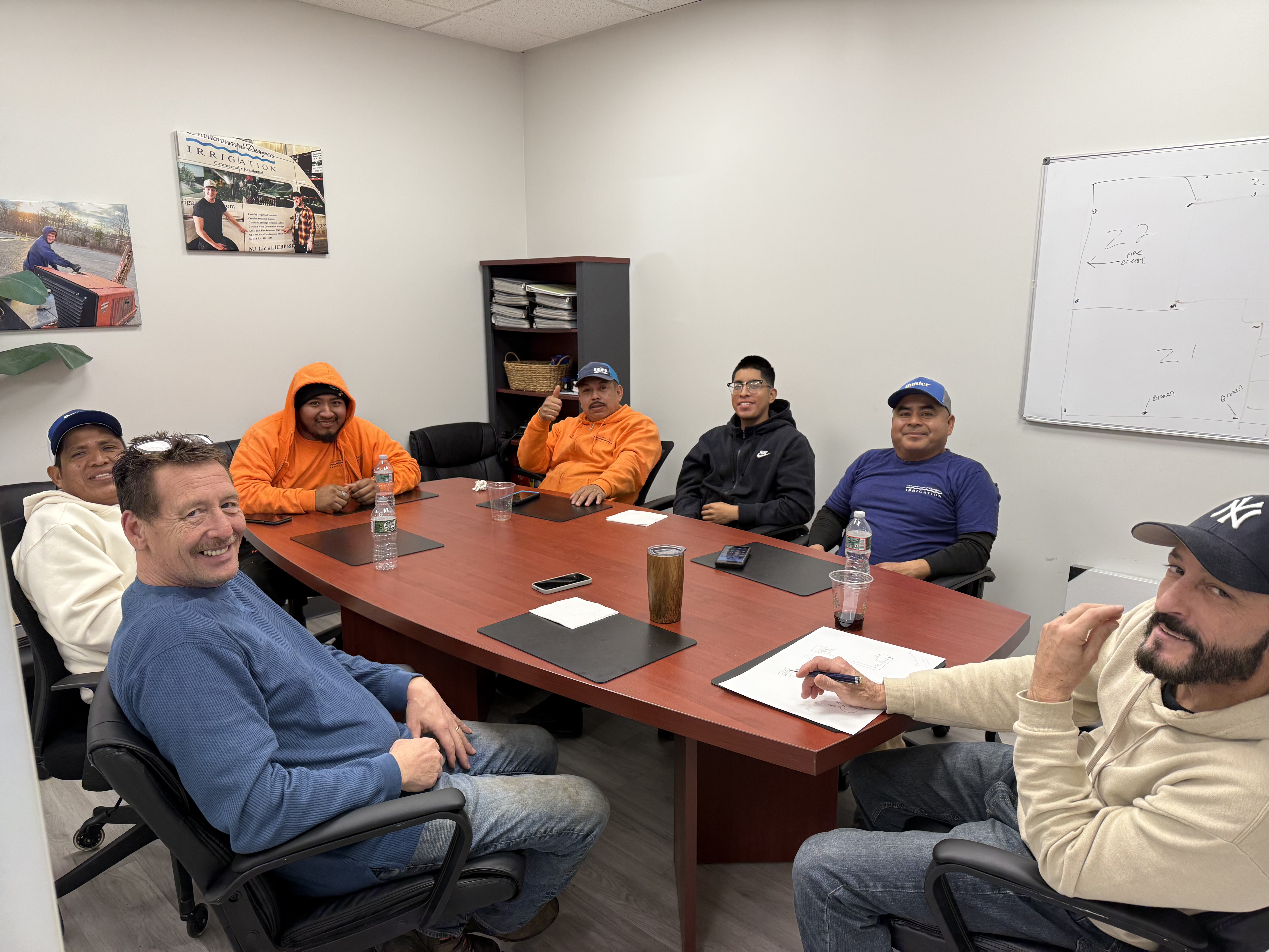 The Environmental Designers Irrigation team gathered around a conference table for a company training and planning meeting.