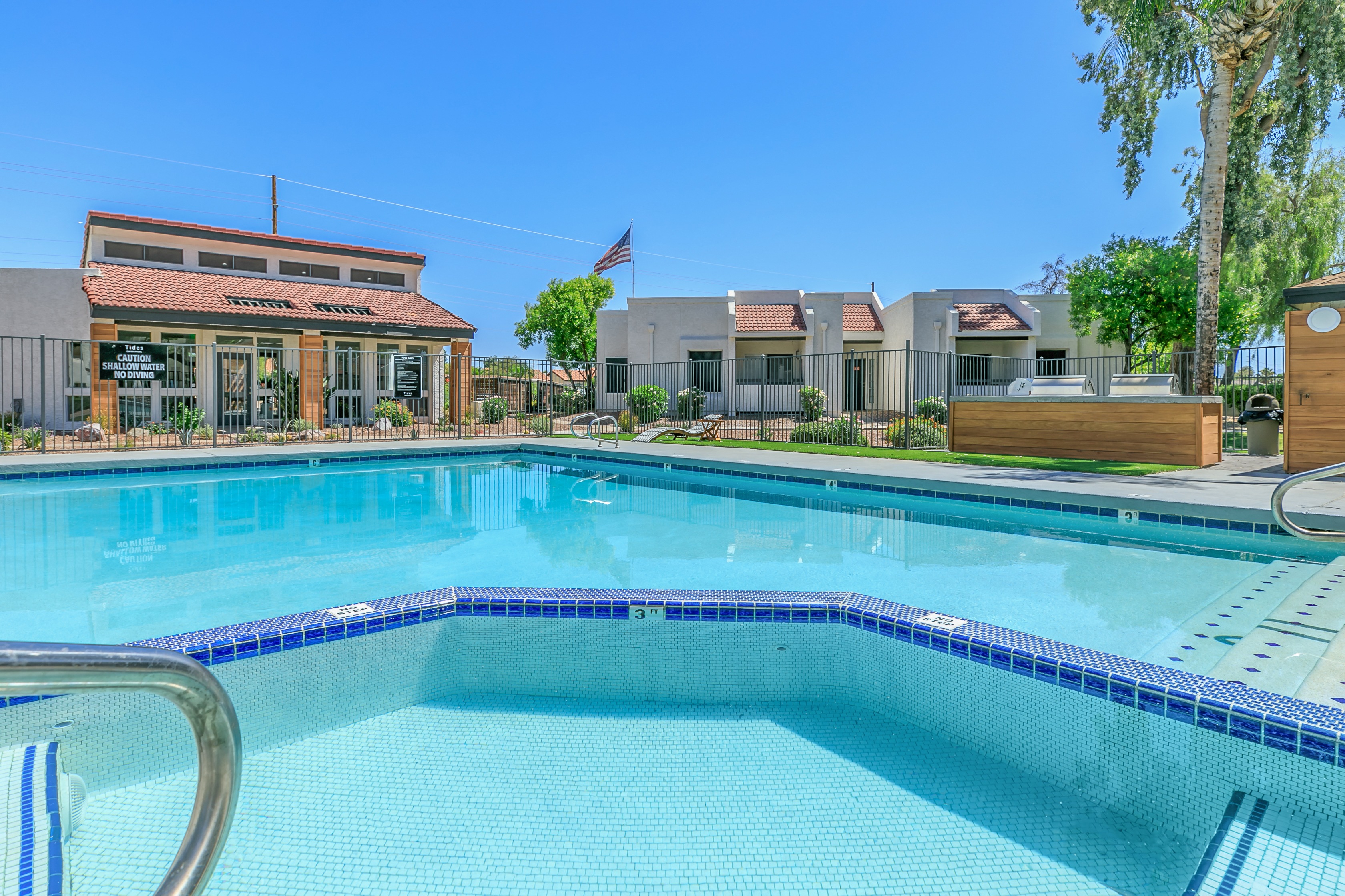 a large swimming pool with apartments in the background