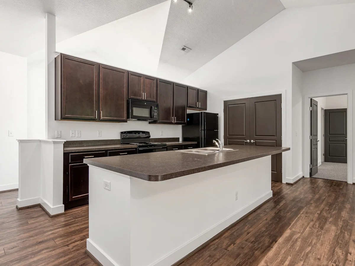 A kitchen with brown cabinets and a white island.
