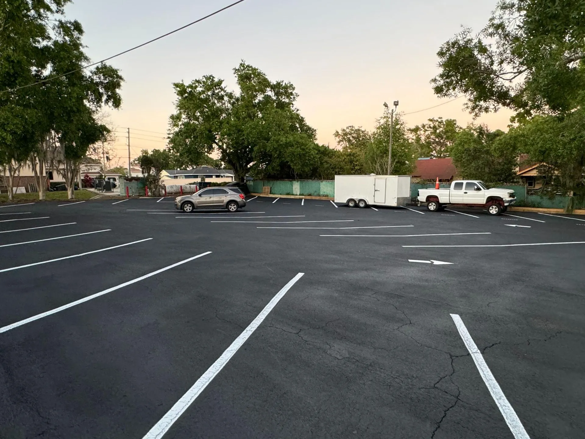 Large commercial parking lot with freshly painted parking space lines, enhancing organization, visibility, and vehicle navigation across the property.