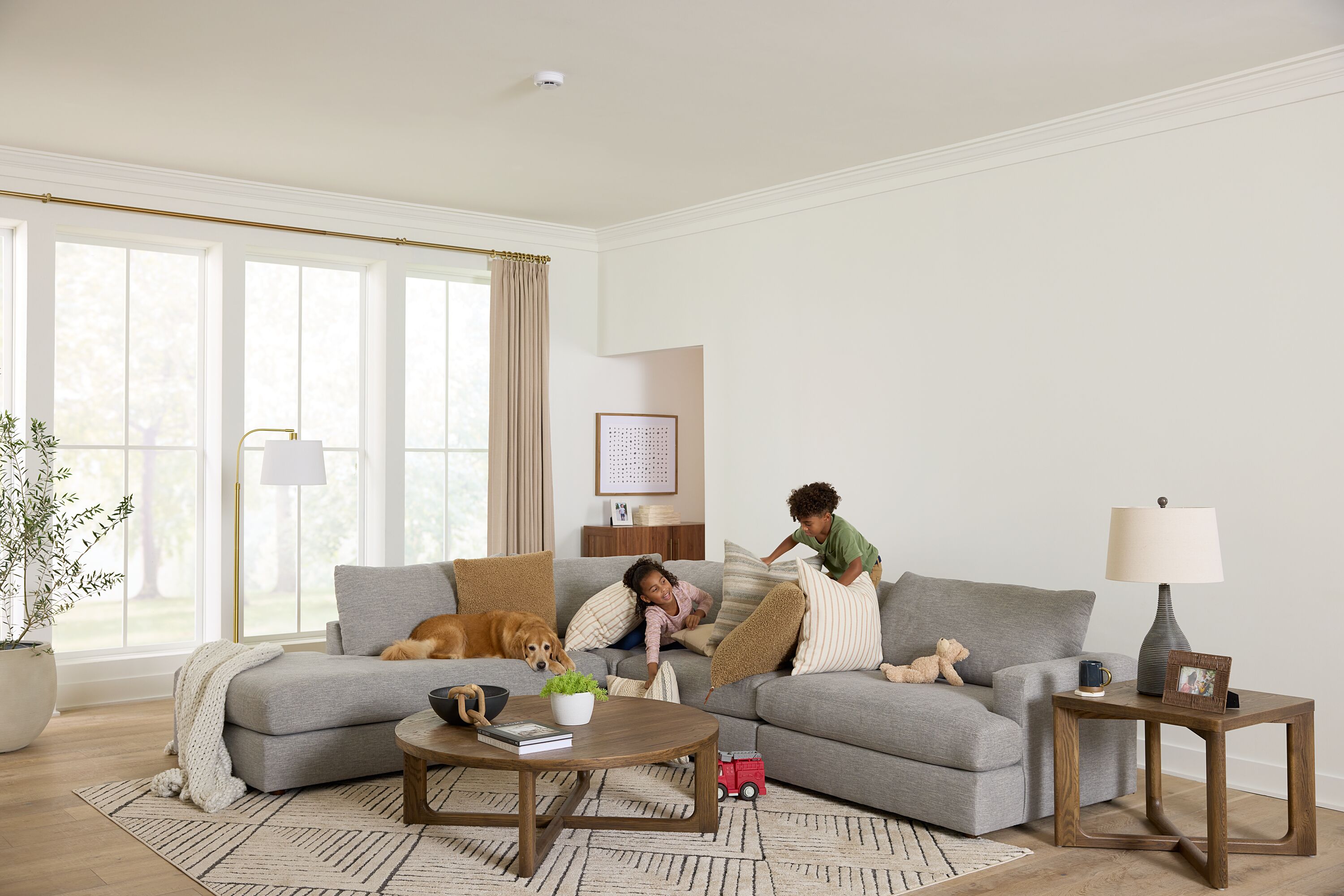 Two kids play on the couch in a living room.