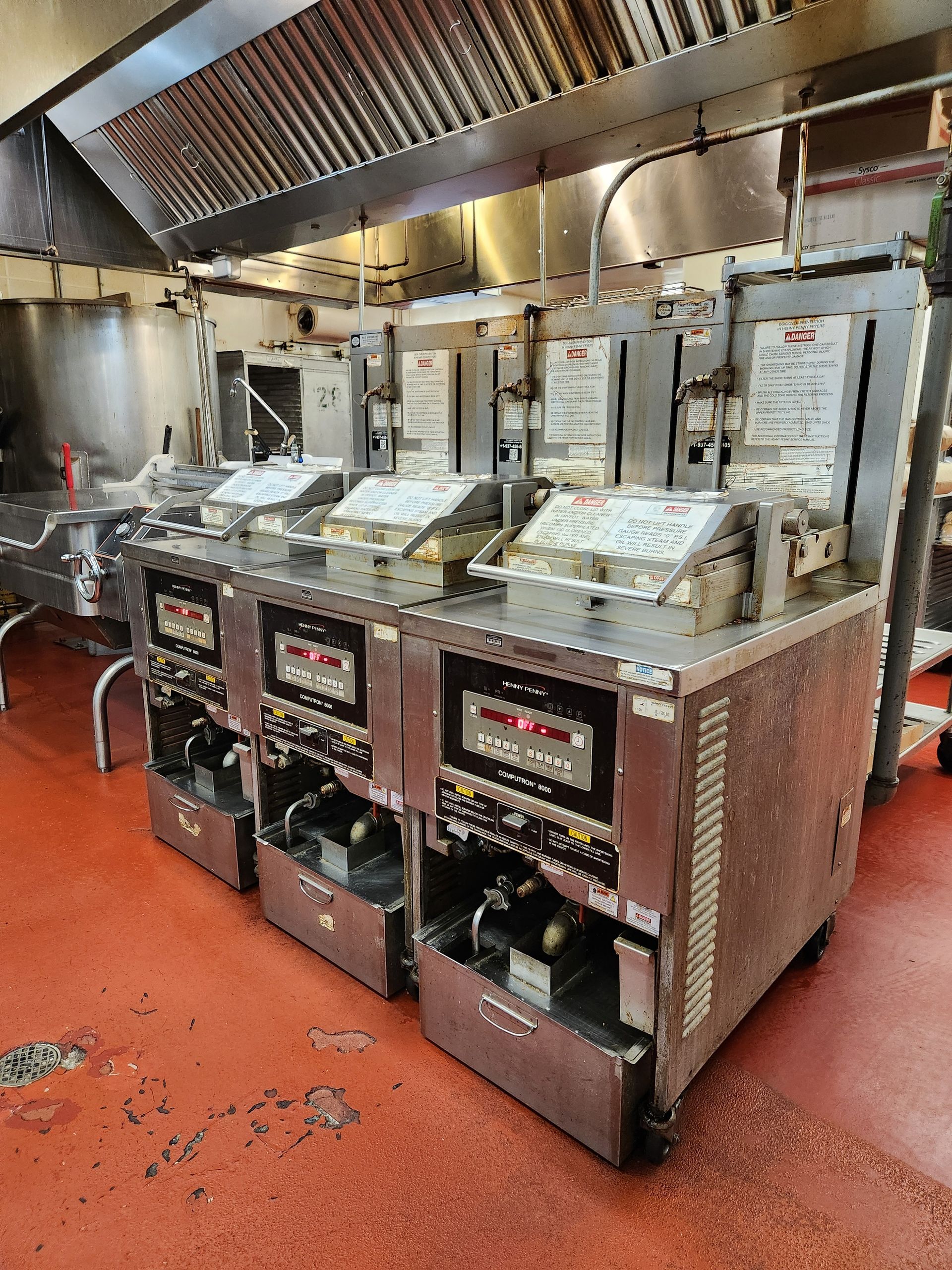 Elite Flame technician servicing a commercial conveyor oven in a restaurant kitchen, using electrica 