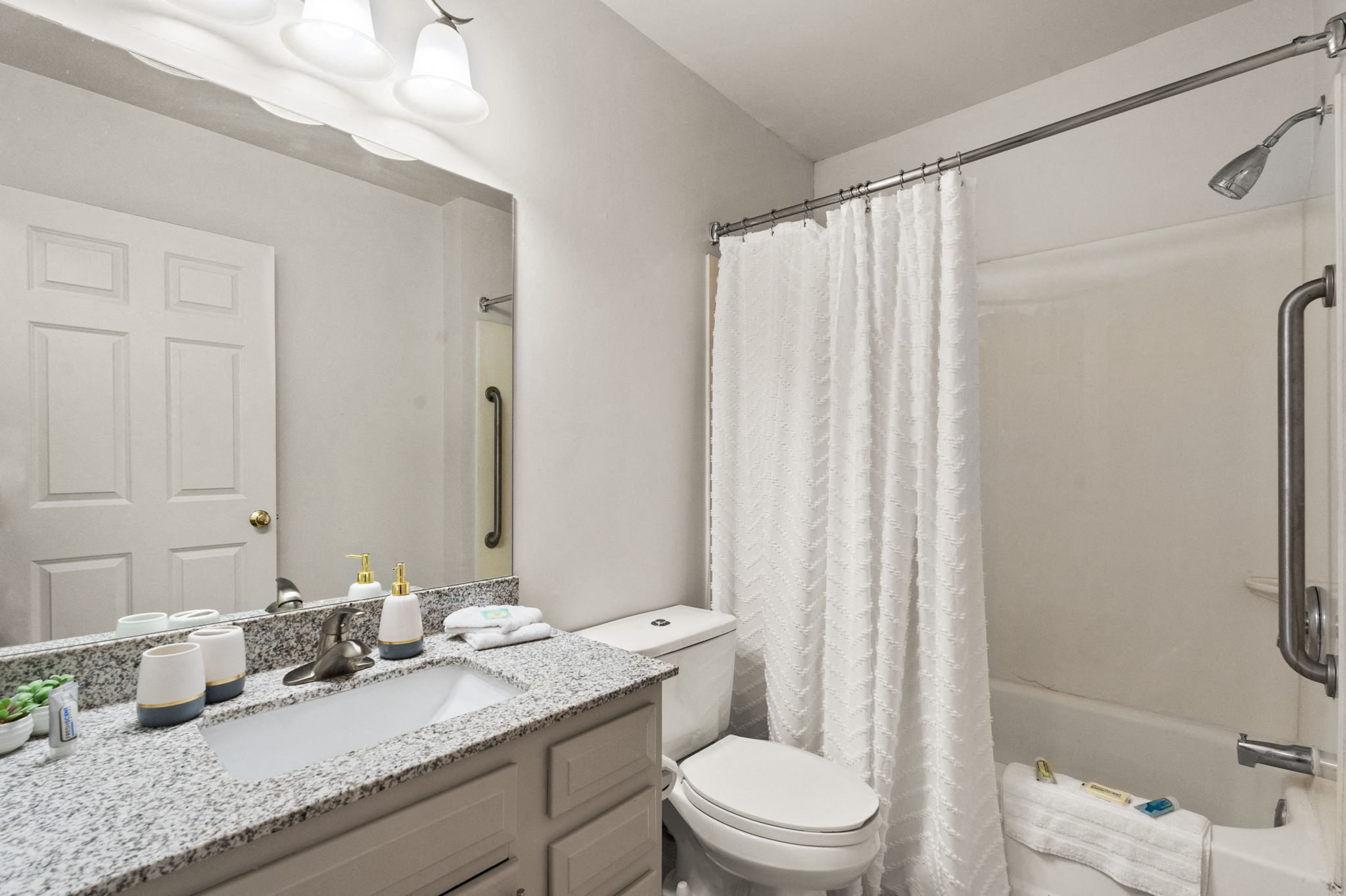 a bathroom with a shower toilet and sink and a mirror at AVIA North Shore in Jeffersonville, IN