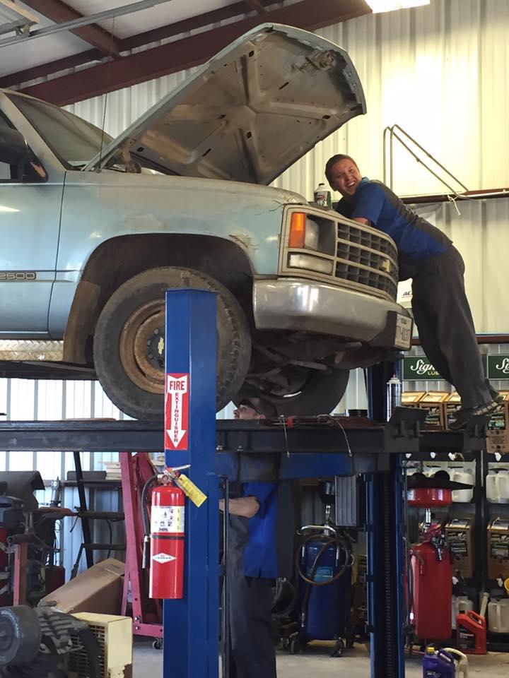 C H Auto Repair mechanics working on a vehicle.