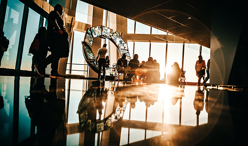 The interior of a modern office setting with the setting sun shining through the windows.