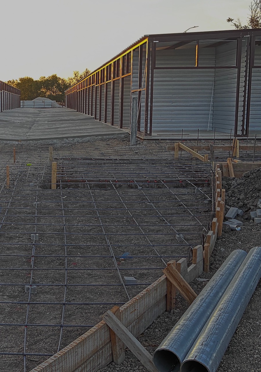 Commercial site development project demonstrating foundation preparation, utility planning, and rein 